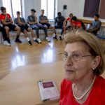 
              Holocaust survivor Eva Szepesi talks to youth players of Bayern Munich in Nuremberg, Germany, Friday, July 29, 2022. Some of Europe's best young soccer players from the under-17 teams of Chelsea, Bayern Munich, Bologna and other international clubs contest the Walther Bensemann Memorial Tournament in Nuremberg, where they also learn the dangers of intolerance by meeting Holocaust survivors, attending workshops and taking part in excursions. (AP Photo/Michael Probst)
            
