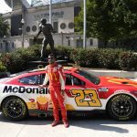 
              NASCAR driver Bubba Wallace poses for photos outside Soldier Field, near the Walter Payton statue, Tuesday, July 19, 2022, in Chicago during a promotional visit to announce a Cup Series street race in the city, to be held July 2, 2023. (AP Photo/Charles Rex Arbogast)
            