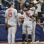 
              Baltimore Orioles' Austin Hays (21) looks on as Jorge Mateo, right, hugs Rougned Odor after Odor's two-run home run off Tampa Bay Rays starter Corey Kluber during the sixth inning of a baseball game Sunday, July 17, 2022, in St. Petersburg, Fla. (AP Photo/Steve Nesius)
            