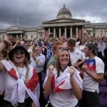 
              England supporters celebrate after Chloe Kelly scored their second goal as they gather in the fan zone in Trafalgar Square to watch on a big screen the final of the Women's Euro 2022 soccer match between England and Germany being played at Wembley stadium in London, Sunday, July 31, 2022. (AP Photo/Frank Augstein)
            