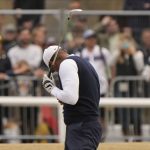 
              Tiger Woods of the US reacts to the dust after playing a shot on the 1st fairway during the first round of the British Open golf championship on the Old Course at St. Andrews, Scotland, Thursday, July 14 2022. The Open Championship returns to the home of golf on July 14-17, 2022, to celebrate the 150th edition of the sport's oldest championship, which dates to 1860 and was first played at St. Andrews in 1873. (AP Photo/Gerald Herbert)
            