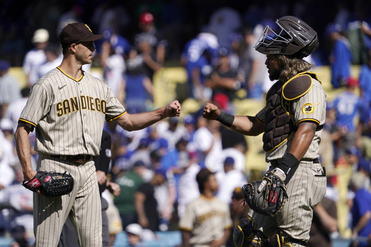 San Diego Padres relief pitcher Taylor Rogers, left, and catcher Jorge Alfaro congratulate each oth...