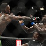 
              Israel Adesanya, left, hits Jared Cannonier in a middleweight title bout during the UFC 276 mixed martial arts event Saturday, July 2, 2022, in Las Vegas. (AP Photo/John Locher)
            