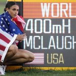 
              Gold medalist Sydney McLaughlin, of the United States, poses by a sign after winning the final of the women's 400-meter hurdles at the World Athletics Championships on Friday, July 22, 2022, in Eugene, Ore. The running mecca that embedded Nike into American culture was an easy choice to host the first track world championships on U.S. soil. It will take time to determine whether Eugene, Oregon lived up to expectations.They say sagging viewership totals and flat revenue across the broader Olympic world make it critical to bring the cornerstone sport of the games back to its glory days in the U.S. before they return to Los Angeles in 2028. (AP Photo/Ashley Landis)
            