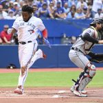 
              Toronto Blue Jays' Vladimir Guerrero Jr., left, scores on a single by Lourdes Gurriel Jr. in the first inning of a baseball game against the Detroit Tigers in Toronto, Saturday, July 30, 2022. (Jon Blacker/The Canadian Press via AP)
            