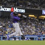 
              Colorado Rockies' Kris Bryant, right, hits a solo home run as Los Angeles Dodgers catcher Will Smith watches during the sixth inning of a baseball game Tuesday, July 5, 2022, in Los Angeles. (AP Photo/Mark J. Terrill)
            