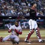 
              Washington Nationals' Victor Robles, left, scores as Arizona Diamondbacks catcher Carson Kelly waits for a throw to home plate during the third inning of a baseball game Saturday, July 23, 2022, in Phoenix. (AP Photo/Ross D. Franklin)
            