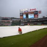
              The Washington Nationals grounds crew spreads the tarp on the field during the eighth inning of a baseball game between the Nationals and the Atlanta Braves, Saturday, July 16, 2022, in Washington. (AP Photo/Nick Wass)
            