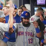
              New York Mets' Luis Guillorme (13) is greeted in the dugout by Francisco Lindor, left, and Mark Canha, right, after hitting a solo home run in the eighth inning of a baseball game against the Atlanta Braves, Monday, July 11, 2022, in Atlanta. (AP Photo/John Bazemore)
            