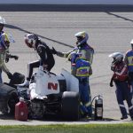 
              FILE - Josef Newgarden, third from left, climbs out of his car after hitting a wall during the IndyCar Series auto race, Sunday, July 24, 2022, at Iowa Speedway in Newton, Iowa. Newgarden was scheduled to be evaluated Thursday, July 28, 2022, to determine if he can race in this weekend's shared event with NASCAR at Indianapolis Motor Speedway. Newgarden collapsed and hit his head at Iowa Speedway following a hard crash. (AP Photo/Charlie Neibergall, File)
            