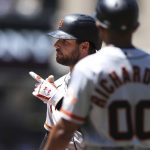 
              San Francisco Giants' Luis Gonzalez, background, gestures toward the dugout after hitting an RBI single against the San Diego Padres as first base coach Antoan Richardson (00) looks on in the fourth inning of a baseball game, Sunday, July 10, 2022, in San Diego. (AP Photo/Derrick Tuskan)
            