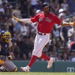 
              Boston Red Sox's Xander Bogaerts, right, scores on a double by J.D. Martinez as Milwaukee Brewers' Omar Narvaez, left, looks on in the fifth inning of a baseball game, Sunday, July 31, 2022, in Boston. (AP Photo/Steven Senne)
            