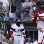
              Chicago White Sox's Eloy Jimenez, right, celebrates as he rounds the bases after hitting a solo home run as Oakland Athletics catcher Stephen Vogt looks on during the seventh inning of a baseball game in Chicago, Sunday, July 31, 2022. (AP Photo/Nam Y. Huh)
            
