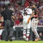 
              Baltimore Orioles' Anthony Santander (25) is slowed by Cincinnati Reds catcher Michael Papierski (26) after being hit by a pitch by reliever Dauri Moreta during the ninth inning of a baseball game Friday, July 29, 2022, in Cincinnati. (AP Photo/Jeff Dean)
            