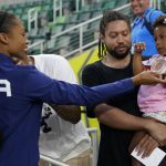 
              Allyson Felix, of the United States, gives her daughter Camryn her bronze medal after the 4x400-meter mixed relay final at the World Athletics Championships Friday, July 15, 2022, in Eugene, Ore. (AP Photo/Charlie Riedel)
            