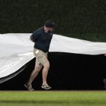 
              Grounds crew workers put the tarp onto the field during the third rain delay in the baseball game between the Milwaukee Brewers and the Minnesota Twins on Tuesday, July 12, 2022, in Minneapolis. (AP Photo/Jim Mone)
            