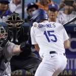 
              Los Angeles Dodgers' Austin Barnes, right, is hit in the back by a pitch as Colorado Rockies catcher Brian Serven, left, reaches for it during the seventh inning of a baseball game Wednesday, July 6, 2022, in Los Angeles. (AP Photo/Mark J. Terrill)
            