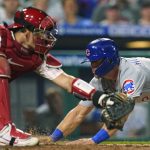 
              Chicago Cubs' Nico Hoerner scores past Philadelphia Phillies catcher J.T. Realmuto during the 10th inning of a baseball game Saturday, July 23, 2022, in Philadelphia. (AP Photo/Matt Rourke)
            