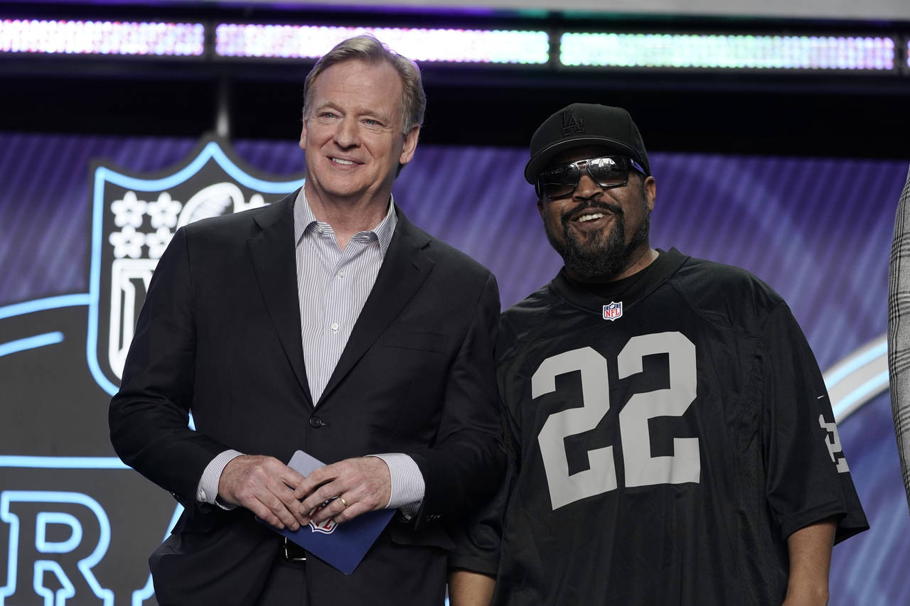 FILE - Rapper Ice Cube, right, poses with NFL Commissioner Roger Goodell during the first round of ...