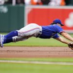 
              Texas Rangers third baseman Charlie Culberson makes a diving stop before forcing out Baltimore Orioles' Cedric Mullins at second base on a ball hit by Trey Mancini during the first inning of a baseball game, Wednesday, July 6, 2022, in Baltimore. (AP Photo/Julio Cortez)
            