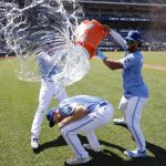 
              Kansas City Royals' Hunter Dozier, bottom, attempts to avoid getting doused by Bobby Witt Jr., left, and MJ Melendez, right, after a baseball game against the Detroit Tigers in Kansas City, Mo., Wednesday, July 13, 2022. (AP Photo/Colin E. Braley)
            