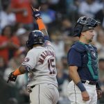 
              Houston Astros' Martin Maldonado gestures after scoring on his solo home run, next to Seattle Mariners catcher Cal Raleigh during the fifth inning of a baseball game Friday, July 22, 2022, in Seattle. (AP Photo/Ted S. Warren)
            