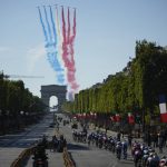 
              FILE - Alphajets of the Patrouille de France fly over the Arc de Triomphe and Champs Elysees as the riders pass during the twenty-first stage of the Tour de France cycling race over 116 kilometers (72 miles) with start in Paris la Defense Arena and finish on the Champs Elysees in Paris, France, Sunday, July 24, 2022. (AP Photo/Daniel Cole, File)
            