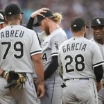 
              Chicago White Sox starting pitcher Michael Kopech, center, puts his hand on his head as he confers with teammates after falling behind in the count to Colorado Rockies' Brian Serven with the bases loaded and one out in the second inning of a baseball game Tuesday, July 26, 2022, in Denver. (AP Photo/David Zalubowski)
            