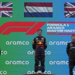 
              Red Bull driver Max Verstappen of the Netherlands, center, stands on the podium with second placed Mercedes driver Lewis Hamilton of Britain, left, and third placed Mercedes driver George Russell of Britain during the Dutch national anthem after he won the Hungarian Formula One Grand Prix at the Hungaroring racetrack in Mogyorod, near Budapest, Hungary, Sunday, July 31, 2022. (AP Photo/Darko Bandic)
            