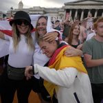 
              England supporters gathered in Trafalgar Square console a German fan after watching their team win in the final of the Women's Euro 2022 soccer match between England and Germany being played at Wembley stadium in London, Sunday, July 31, 2022. (AP Photo/Frank Augstein)
            
