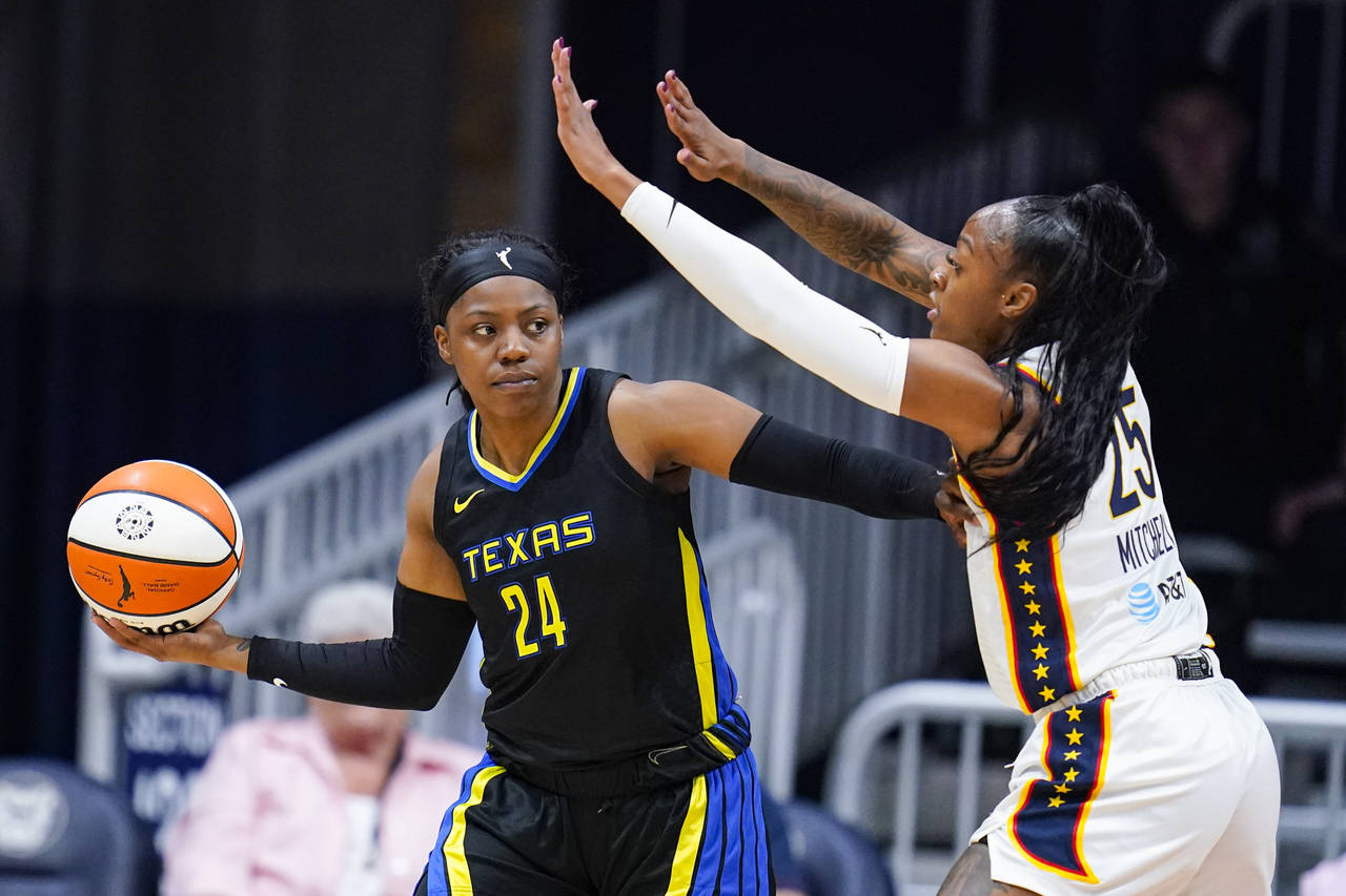 Dallas Wings guard Arike Ogunbowale (24) holds off Indiana Fever guard Tiffany Mitchell (25) in the...