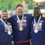 
              Gold medalist Ryan Crouser, of the United States, center, stands on the podium with silver medalist Joe Kovacs, of the United States, left, and bronze medalist Josh Awotunde, of the United States, during a medal ceremony for the men's shot put final at the World Athletics Championships on Sunday, July 17, 2022, in Eugene, Ore. (AP Photo/David J. Phillip)
            