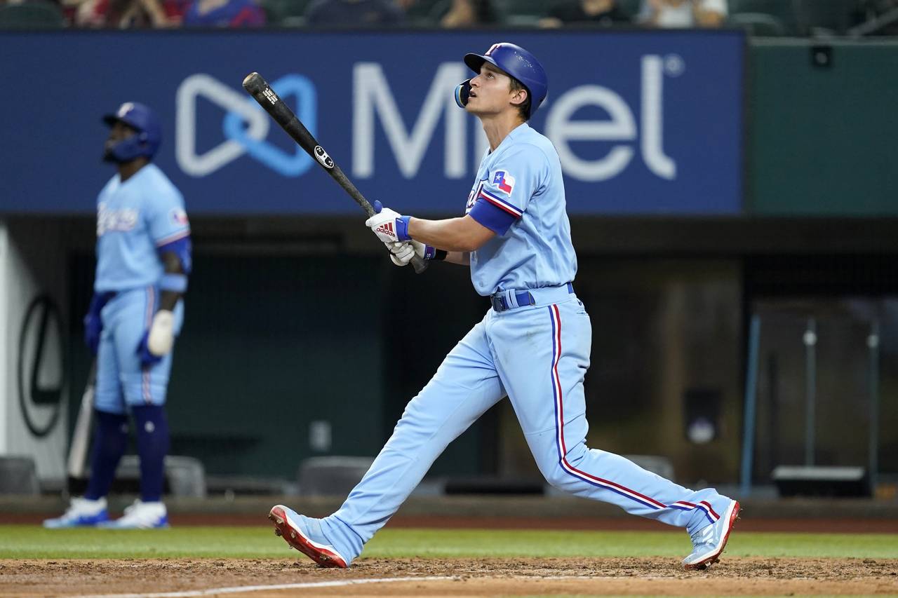 Texas Rangers' Corey Seager watches the flight of his run-scoring sacrifice fly in the fifth inning...