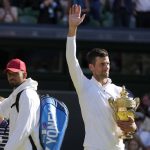 
              Serbia's Novak Djokovic, right, holds the winners trophy as he celebrates after beating Australia's Nick Kyrgios, left, to win the final of the men's singles on day fourteen of the Wimbledon tennis championships in London, Sunday, July 10, 2022. (AP Photo/Alastair Grant)
            