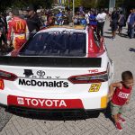 
              Two-year-old Brooks Elmendorf, from Dallas, touches a car as Bubba Wallace, back to camera, stands on the other side of it at Navy Pier on Tuesday, July 19, 2022, in Chicago, during a promotion for a Cup Series street race to be held in the city, July 2, 2023. (AP Photo/Charles Rex Arbogast)
            