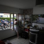 
              FILE - A woman cheers the riders, as she stands at her window, during the fourth stage of the Tour de France cycling race over 171.5 kilometers (106.6 miles) with start in Dunkerque and finish in Calais, France, Tuesday, July 5, 2022. (AP Photo/Daniel Cole, File)
            