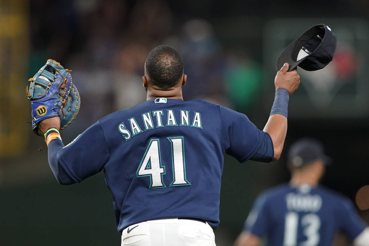 Seattle Mariners first baseman Carlos Santana reacts to the crowd after the team's baseball game ag...