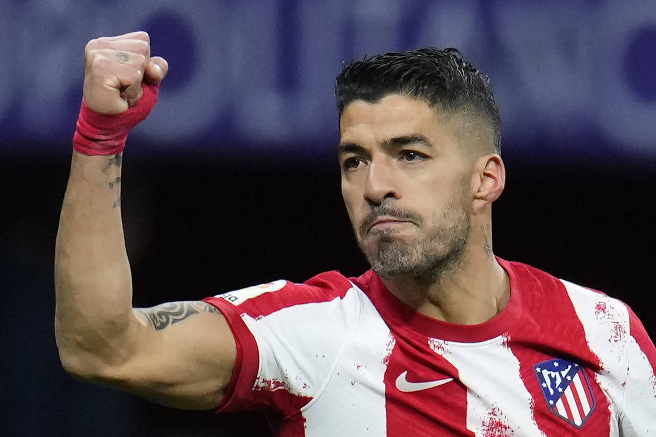 FILE - Atletico Madrid's Luis Suarez celebrates after scoring a penalty, his side's second goal, du...