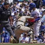 
              Los Angeles Dodgers' Mookie Betts, right, is tagged out at home by San Diego Padres catcher Jorge Alfaro, center, while trying to score on a single by Freddie Freeman as home plate umpire Charlie Ramos watches during the fourth inning of a baseball game Sunday, July 3, 2022, in Los Angeles. (AP Photo/Mark J. Terrill)
            