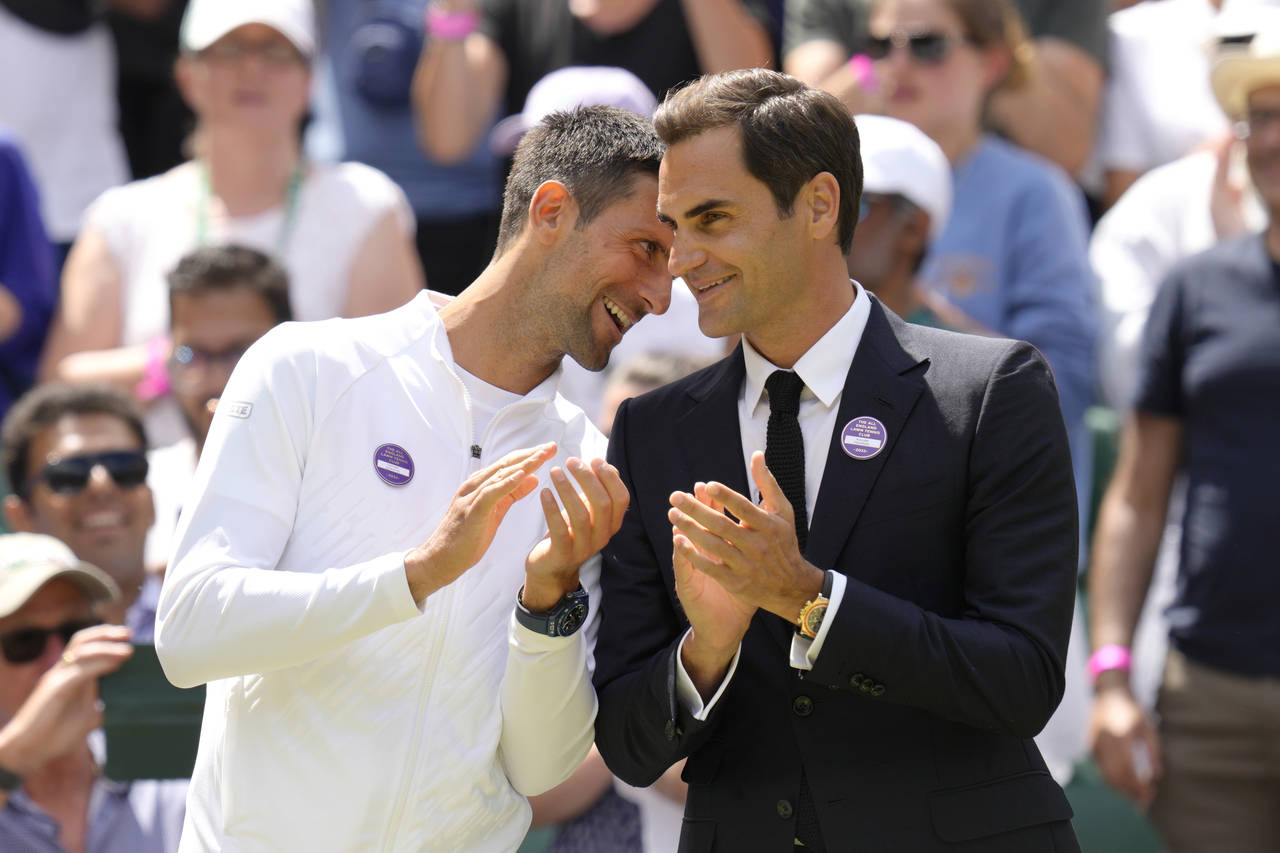 Serbia's Novak Djokovic and Switzerland's Roger Federer speak during a 100 years of Centre Court ce...