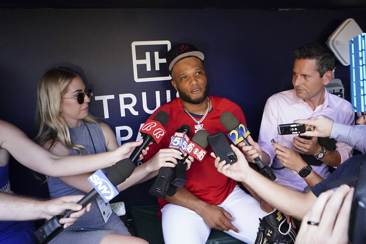 Newly acquired Atlanta Braves second baseman Robinson Cano, center, speaks to the media before a ba...