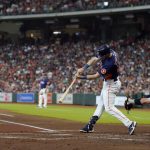 
              Houston Astros' Kyle Tucker (30) hits a RBI-single as Seattle Mariners catcher Cal Raleigh (29) reaches for the pitch during the first inning of a baseball game Sunday, July 31, 2022, in Houston. (AP Photo/David J. Phillip)
            