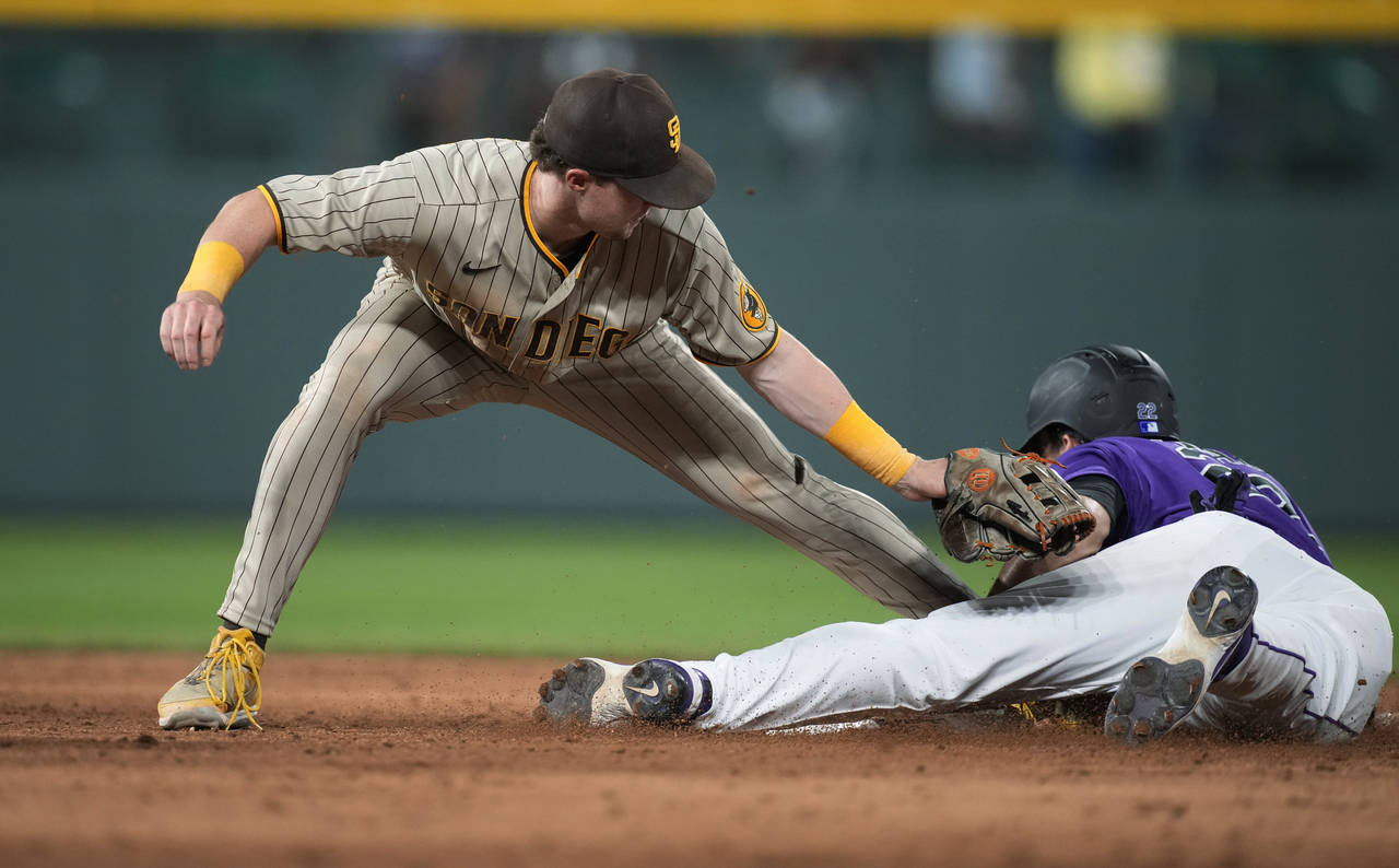 San Diego Padres second baseman Jake Cronenworth, left, applies a late tag as Colorado Rockies' Sam...