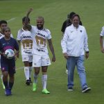 
              Accompanied by youth players and club president, Leopoldo Silva, right center, Brazilian Dani Alves waves during his presentation as a new member of the Pumas UNAM soccer club, on the pitch at the Pumas training facility in Mexico City, Saturday, July 23, 2022. (AP Photo/Marco Ugarte)
            