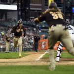 
              San Diego Padres' Jorge Alfaro, foreground, gestures to Trent Grisham who prepares to cross home plate on an RBI-single by Ha-Seong Kim in the fifth inning of a baseball game against the Detroit Tigers, Monday, July 25, 2022, in Detroit. (AP Photo/Jose Juarez)
            