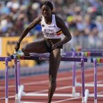 
              Anne Zagre, of Belgium, competes alone in a heat in the women's 100-meter hurdles at the World Athletics Championships on Saturday, July 23, 2022, in Eugene, Ore. Zagre in lane six got hampered during the race at the 10th hurdle by Nia Ali, of the USA in lane five. Ali of the USA knocked a hurdle over and got in lane six, affecting Zagre. (AP Photo/Ashley Landis)
            