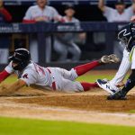 
              Boston Red Sox's Xander Bogaerts, left, slides past New York Yankees catcher Kyle Higashioka to score on a wild pitch by relief pitcher Michael King during the 11th inning of a baseball game Friday, July 15, 2022, in New York. (AP Photo/Frank Franklin II)
            
