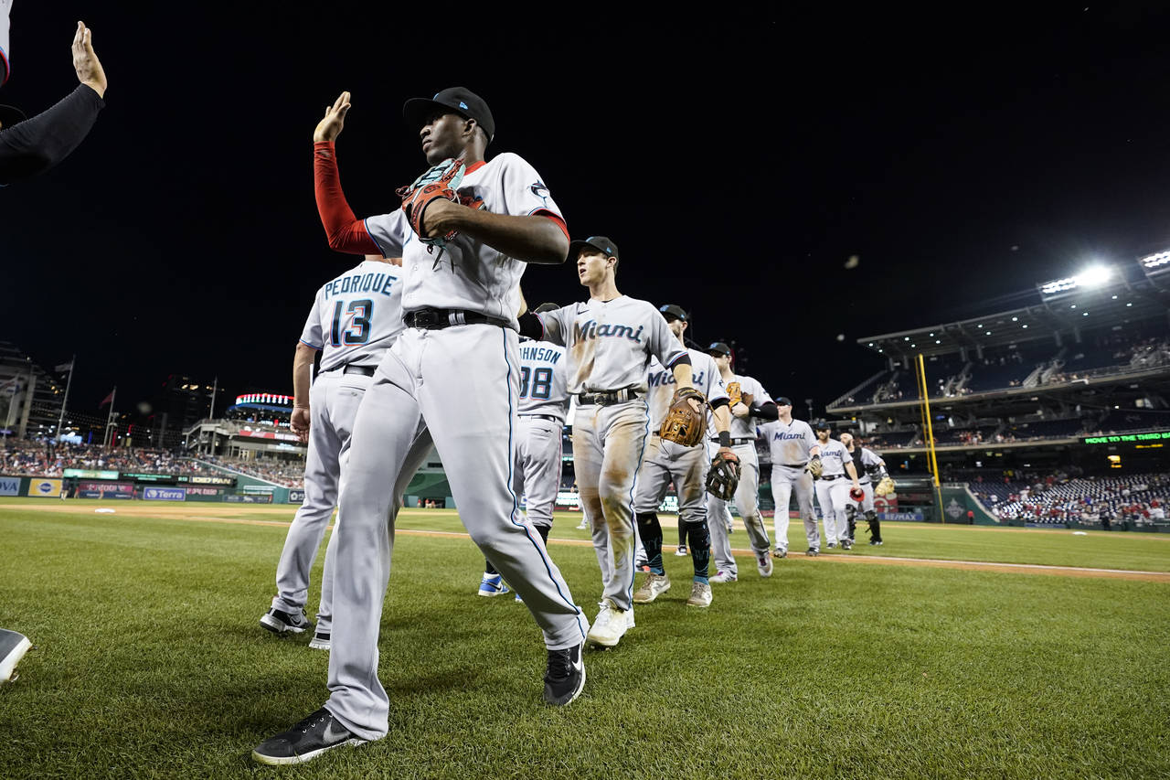 Miami Marlins' Jesus Sanchez, front, celebrates with teammates after a baseball game against the Wa...