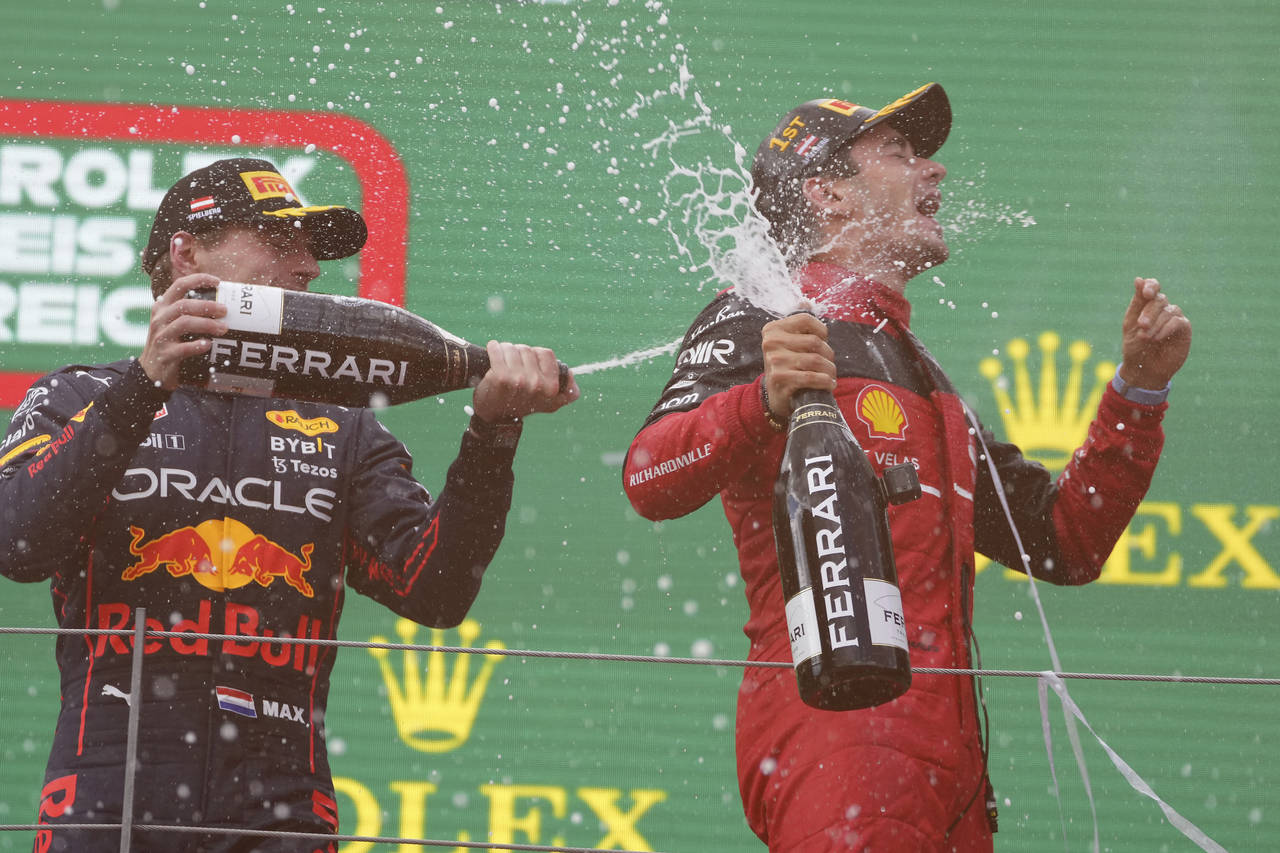 Ferrari driver Charles Leclerc, right, of Monaco, celebrates on the podium with second placed Red B...