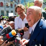 
              The former Fifa President, Joseph Blatter surrounded by media representatives, waves to the press in front of the Swiss Federal Criminal Court in Bellinzona, Switzerland, at the last day of the trail, after the verdict has been announced, Friday, July 8, 2022. The trial ended with an acquittal. Blatter and Michel Platini, former president of the the European Football Association (Uefa), stood trial before the Federal Criminal Court over a suspicious two-million payment. The Federal Prosecutor's Office accused them of fraud. The defense spoke of a conspiracy. (Ti-Press/Alessandro Crinari/Keystone via AP)
            